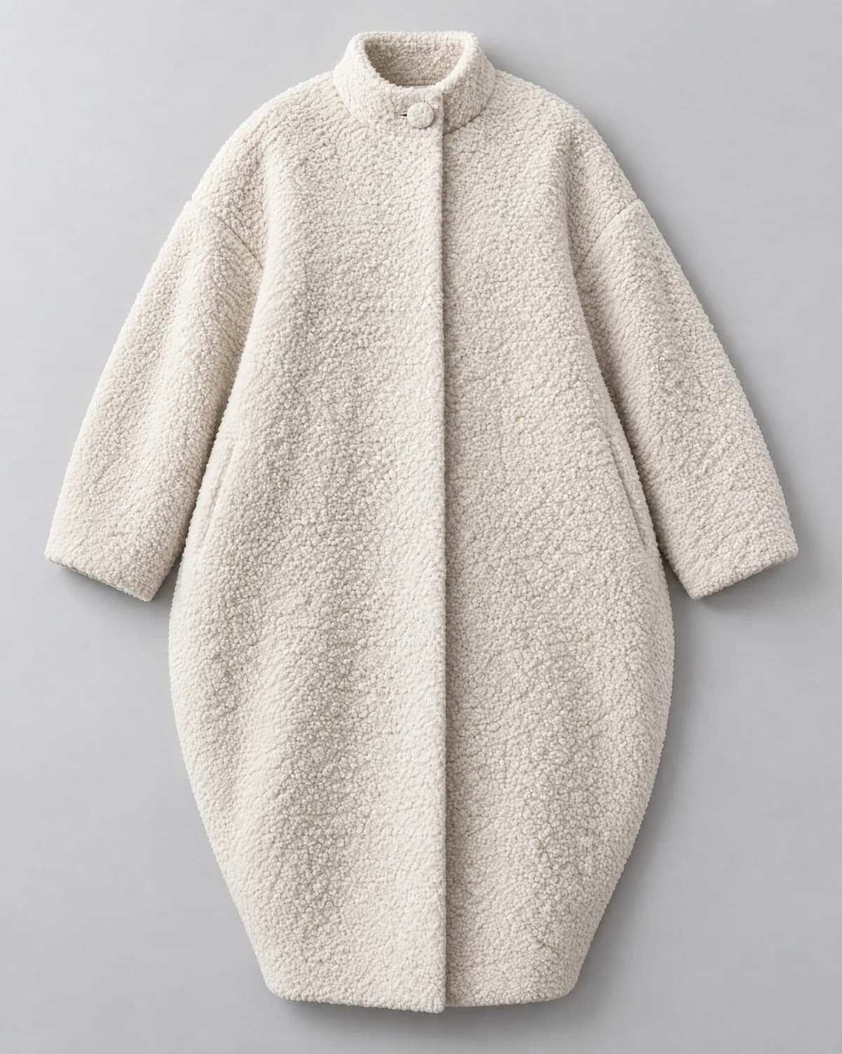 The flat-lay of the bouclé cocoon coat, the input of this look